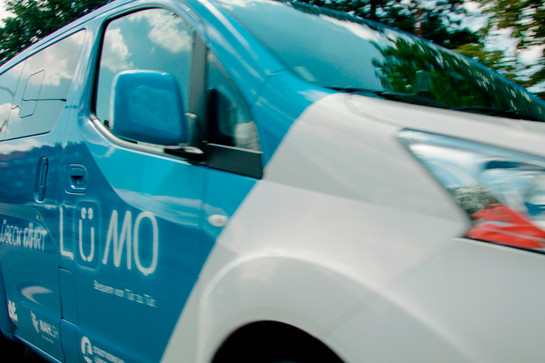 Blick auf ein blau weißes Lümo Auto