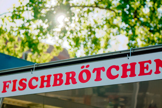 Ein weißes Schild wo Fischbrötchen draufsteht