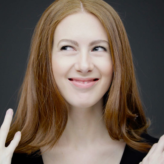 Eine rothaarige Frau gestikuliert mit ihren Händen