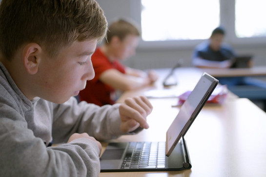 Ein Schüler tippt auf einem Ipad