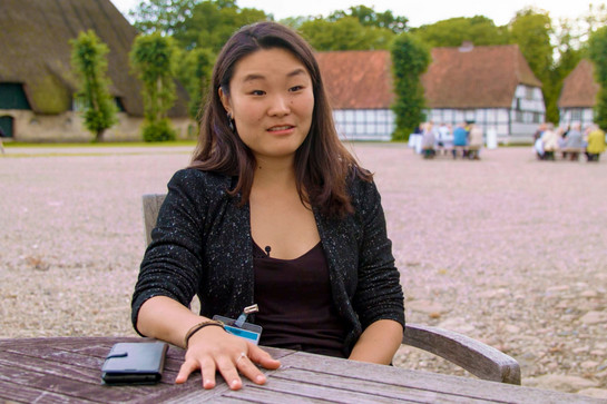 Eine Frau sitzt an einem Gartentisch
