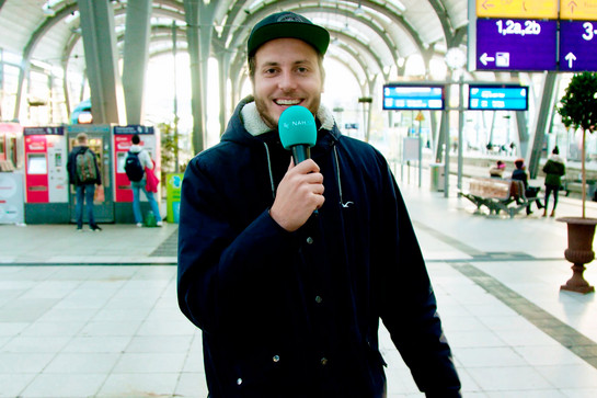 Standbild eines Nah.sh Moderators der am Bahnsteig steht