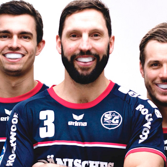 Drei Handballspieler tragen einen Mundschutz