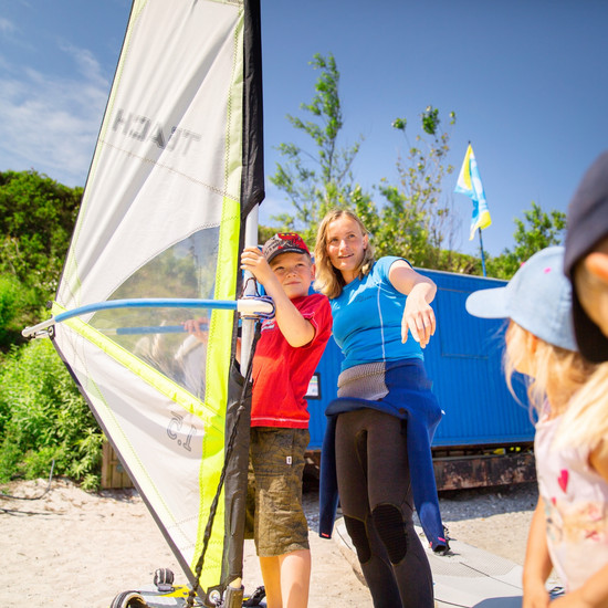 Ein Kind übt Windsurfen