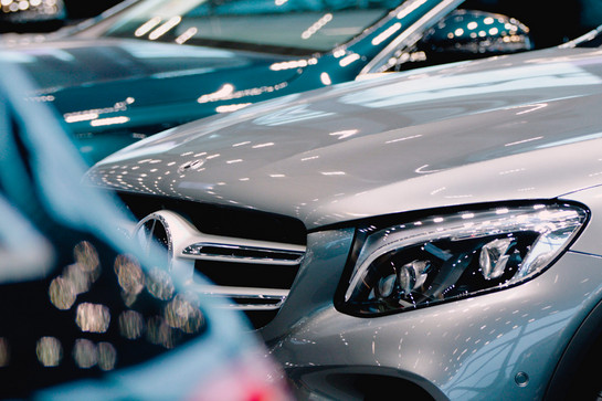Zwei Mercedes Benz stehen in einer Halle