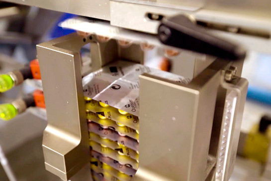 Pillenpackungen liegen in einer Maschine