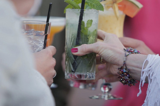 Nahaufnahme, zwei Frauen stoßen mit Cocktails an.