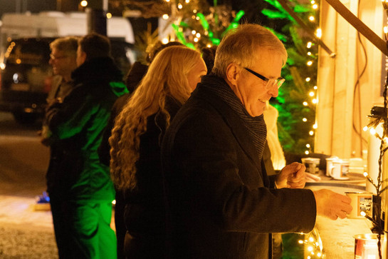 Älterer Herr mit Becher in der Hand am Punschstand