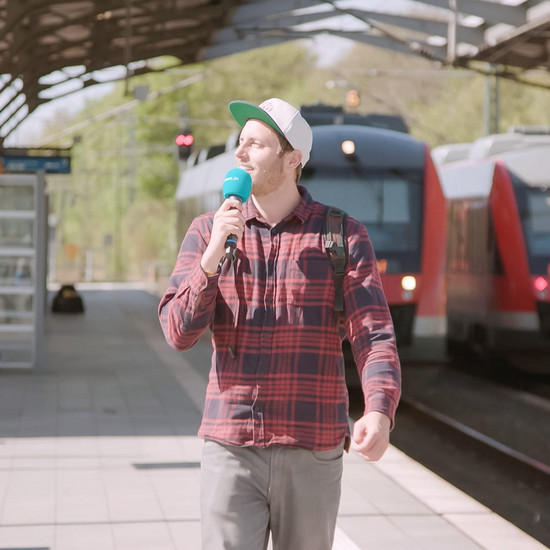 Bahnhofsmission Ein Mann geht am Bahnsteig entlang