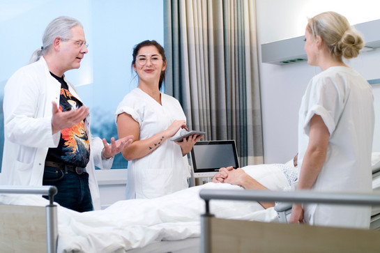Medizinisches Personal steht um das Bett eines Patienten