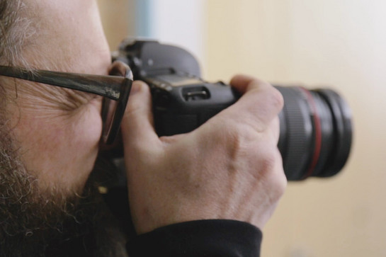 Nahaufnahme eines Mannes der mit einer Kamera fotografiert