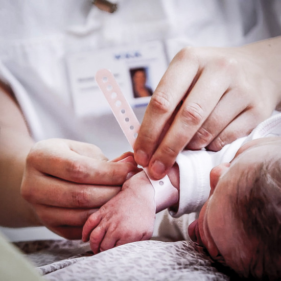 Ein Kind kriegt ein weißes Band um den Arm