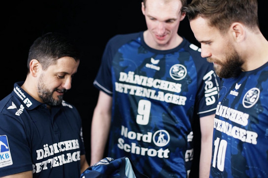 bb_sg_trikot_praesentation_2016_17_teaser_03_hauptteaser.jpg Drei SG Spieler gucken sich ein Trikot an
