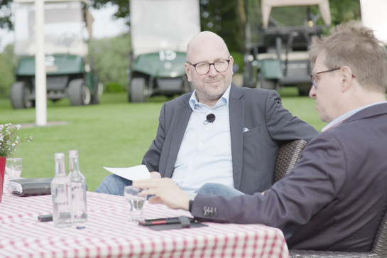 Zwei Männer sitzen an einem Tisch und besprechen sich