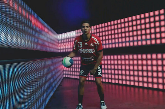 Ein SG Spieler prellt vor einer LED Wand