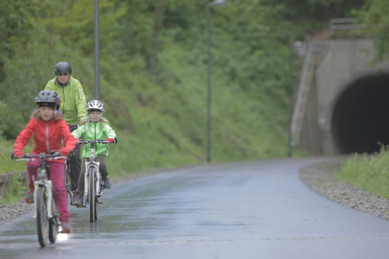 Zwei Kinder und ein Mann fahren Fahrrad