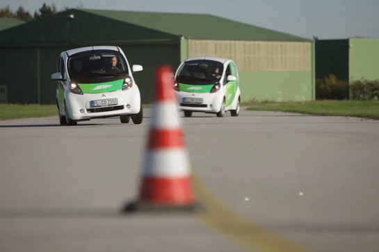 Zwei Autos der Stadtwerke Flensburg fahren Slalom auf einem Parkour