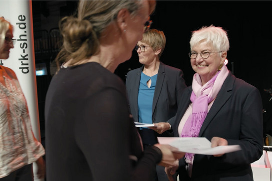 Eine Dame nimmt eine Urkunde entgegen