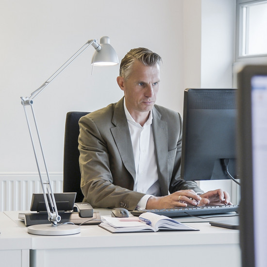 Konto Kjer Geschäftsführer sitzt vor einem Bildschirm