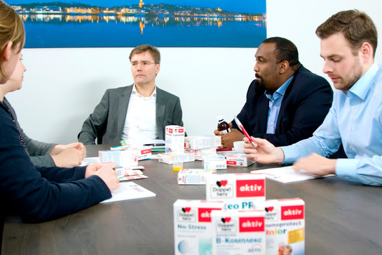Queisser Pharma Mitarbeiter sitzen an einem Tisch