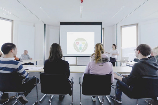 Personen hören einer Person im Meeting zu