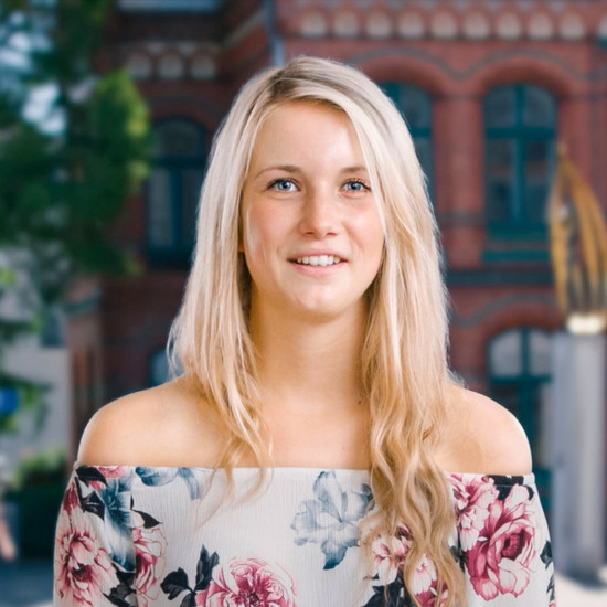 Standbild einer blonden Frau mit Blumen Oberteil
