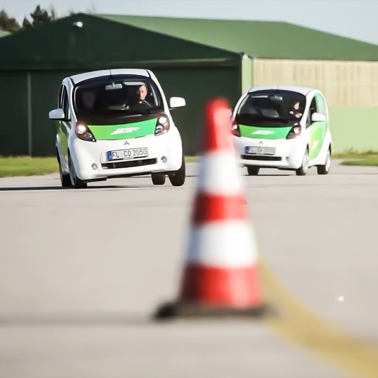 Volt auf Asphalt weiße E Autos fahren Slalom