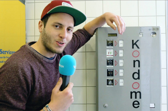 Lars lehnt sich an einen Kondomautomaten