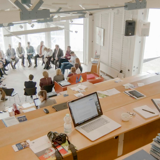 Blick auf eine Personengruppe die im Kreis sitzen