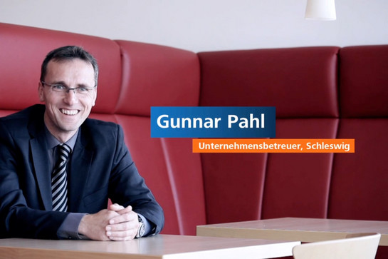 Gunnar Pahl sitzt auf einem rotem Ledersofa 