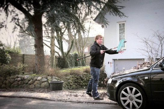 Ein Mann fegt Laub
