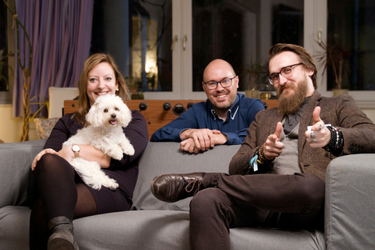 Drei Personen sitzen auf der Couch