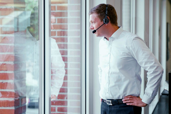 Ein Sydbank Mitarbeiter trägt ein Headset