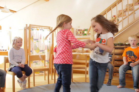 Zwei Kinder tanzen im Kreis