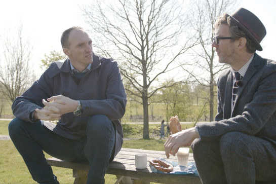 Jim Lacy und Holger Glandorf unterhalten sich auf einer Parkbank