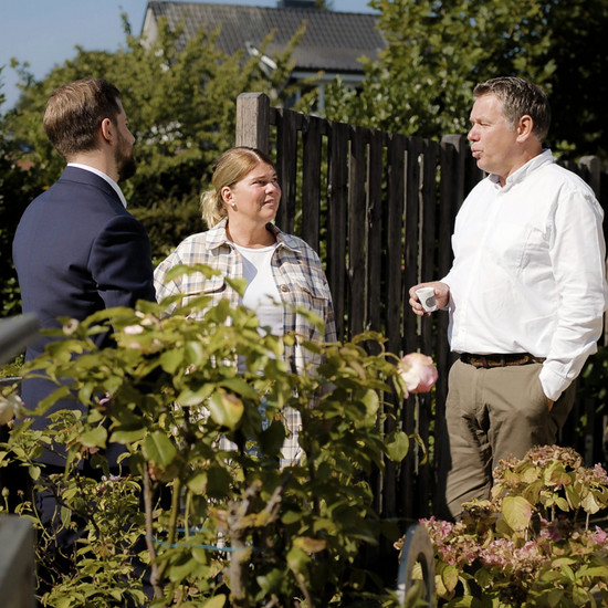 Generationen-management Drei Personen unterhalten sich in einem Garten