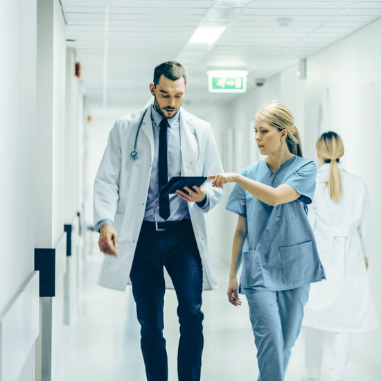 Eine Krankenschwester gibt einem Arzt Unterlagen