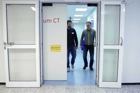 Zwei Männer gehen durch den Krankenhausflur