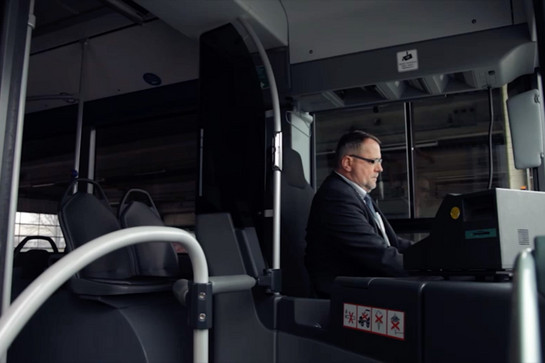 Ein Busfahrer sitzt in einem dunklen Bus