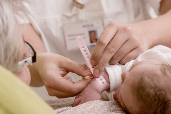 Ein Baby bekommt ein Armband umgelegt
