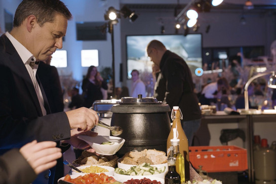 Herr, der sich am Buffet Salat auffüllt