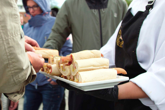 Eine Frau verteilt Hotdogs