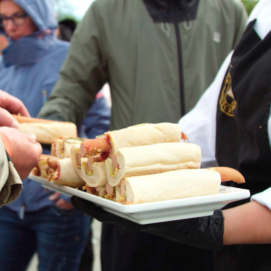 Eine Frau verteilt Hotdogs