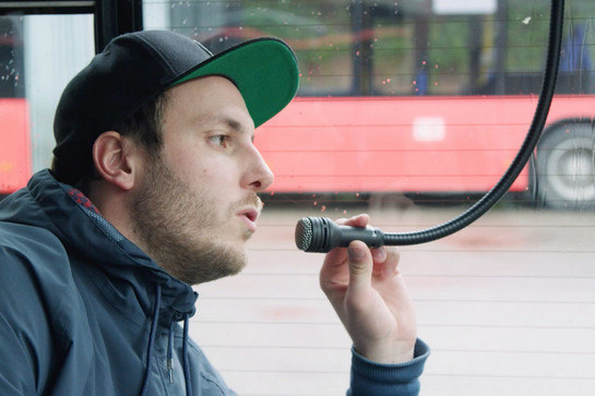 Ein Mann spricht in das Busmikrofon
