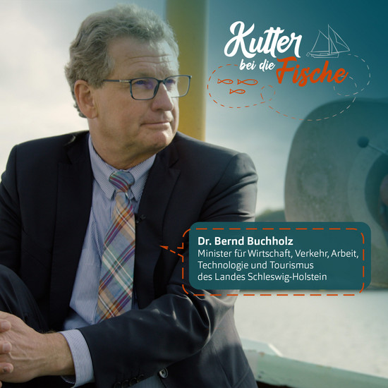 Bernd Buchholz trägt einen Anzug mit bunter Kravatte