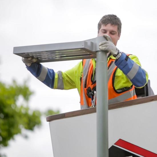 Ein Mann repariert ein Straßenlicht