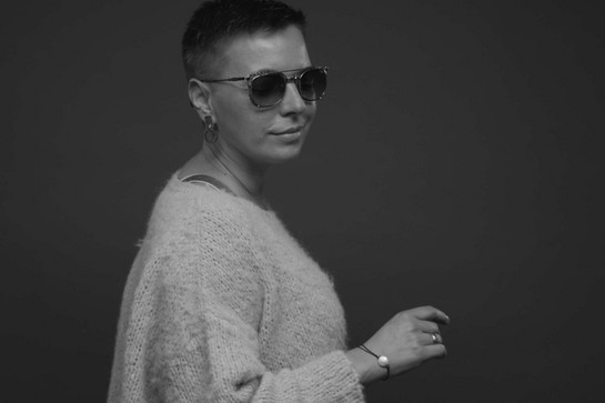 Frau mit kurzen, dunklen Haaren trägt Sonnenbrille