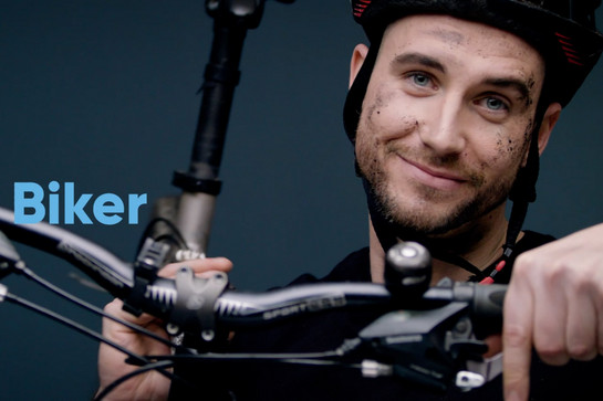 Ein Mann mit Fahrradhelm lächelt in die Kamera