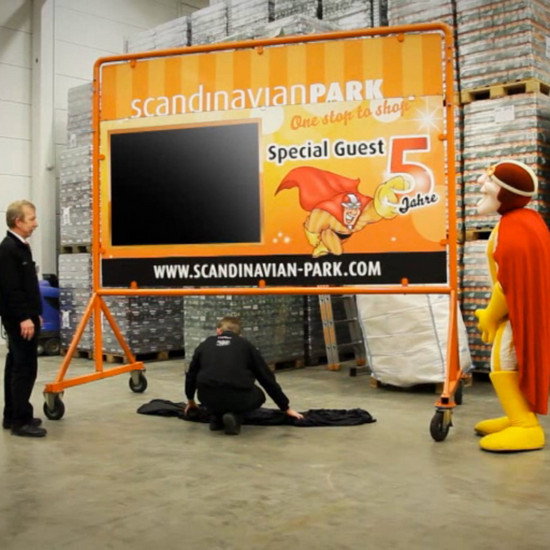 Drei Personen stehen um ein großes Mr Scandi Schild