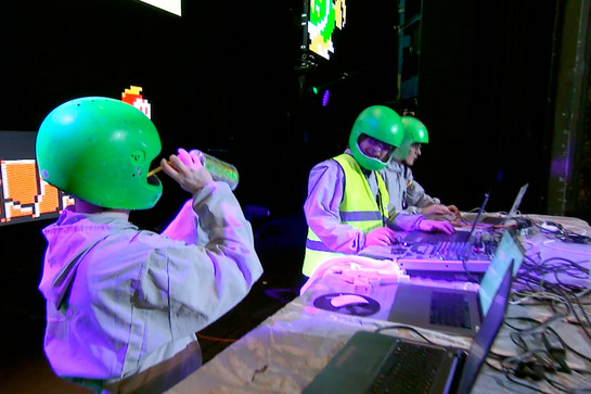 bb_pennywise_teaser_03.jpg Drei Männer mit grünem Helm stehen an einem DJ Pult